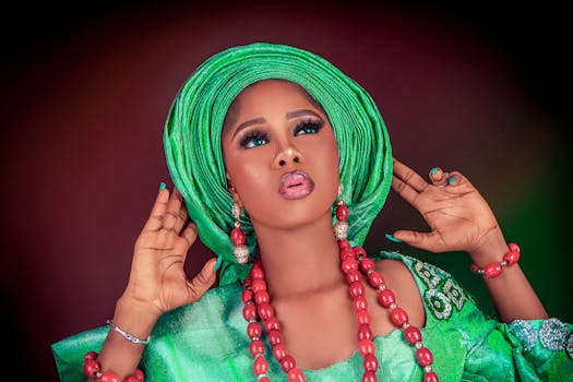 Striking portrait of woman in colorful African attire with bold makeup and jewelry.
